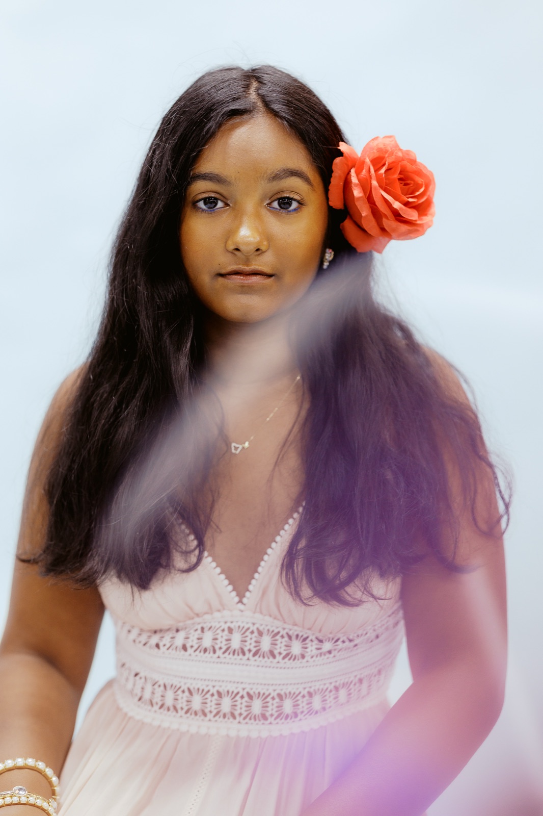 Portrait of Anya Gupta with a coral rose in her hair