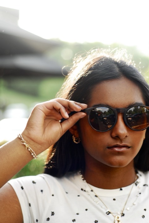 Anya tipping her sunglasses, backlit by golden light