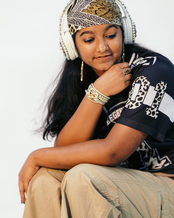 Anya in a leopard-print bandana resting her chin on her hand, lost in the song