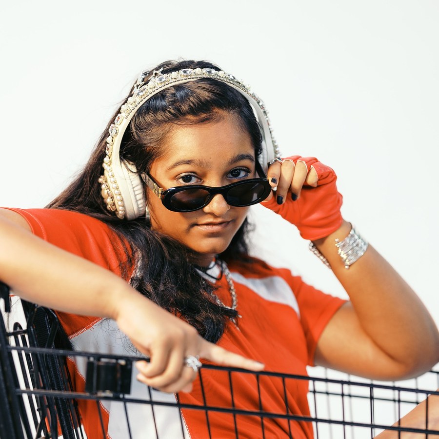 Not For You — Anya Gupta in a red striped tee and white headphones, lowering her sunglasses, leaning on a shopping cart